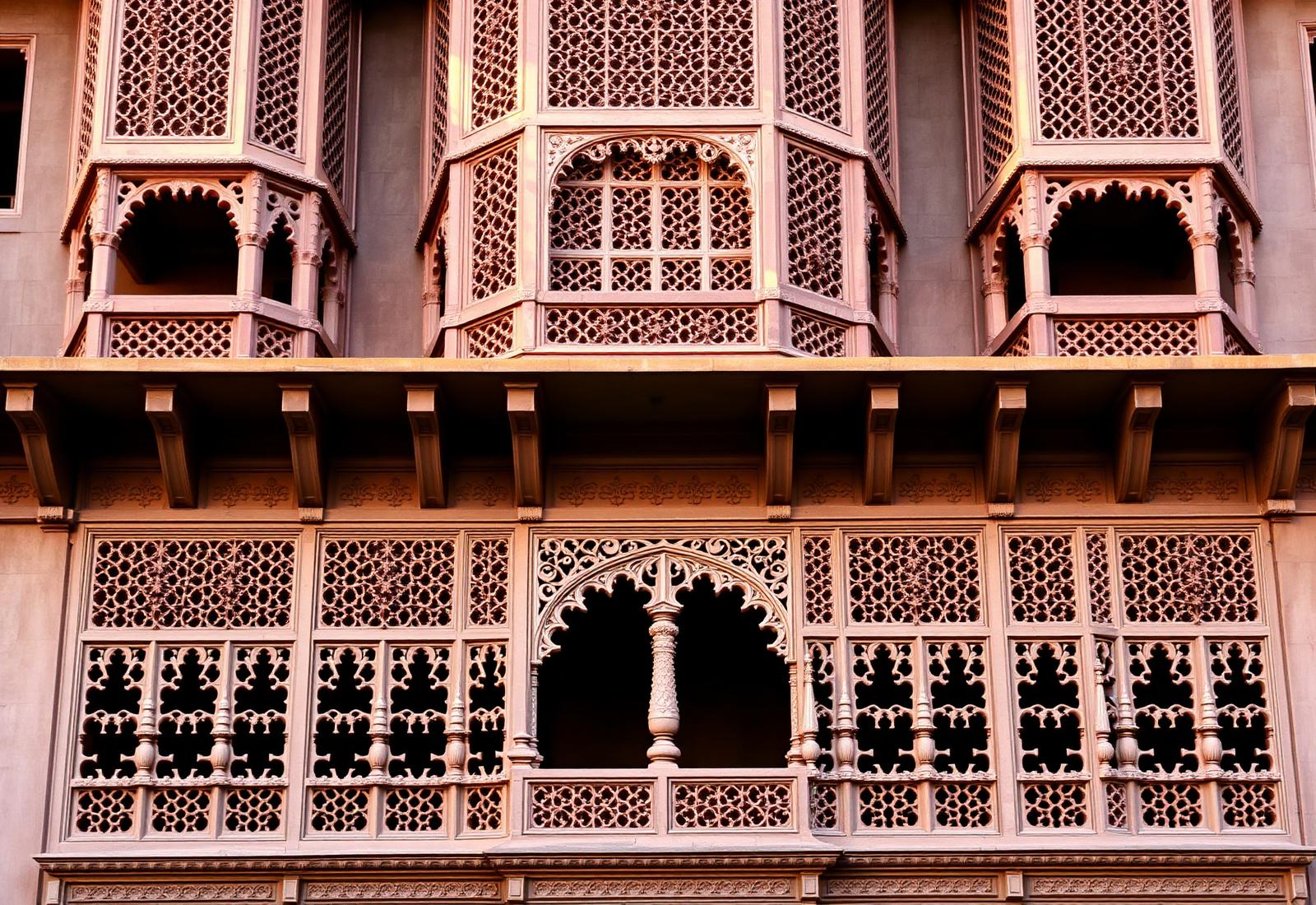 Carved red sandstone facade of a Bikaner haveli in warm light